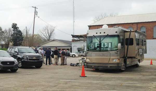 FBI agents meet outside a portable command post in Port Gibson, Miss.