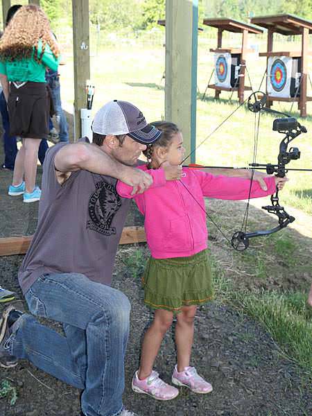 An instructor teaching a child to shoot a bow during a 2014 event at the EE Wilson Archery Range. Drop by the range the third Saturday of every month from March – November to learn archery skills from volunteers with Oregon Bow Hunters.