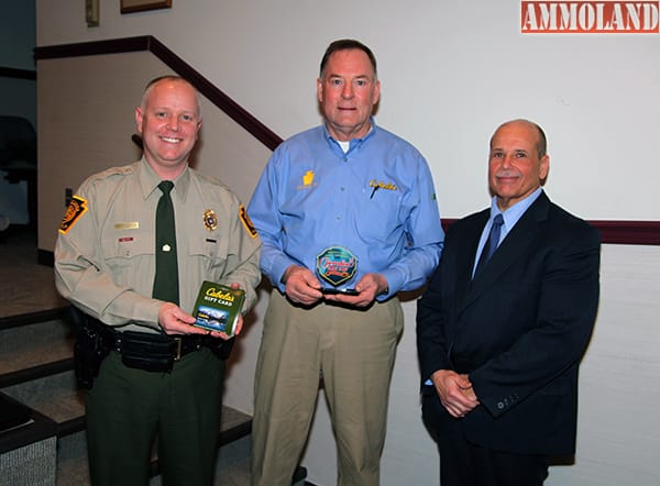 Chad Eyler, the Game Commission's special permits division chief and an Operation Game Thief administrator, left, stands beside Ron Leh, retail marketing manager for Cabela's Hamburg store, and Game Commission Bureau of Wildlife Protection Director Thomas P. Grohol as Leh is presented an award for the outfitter's support of the Operation Game Thief program.