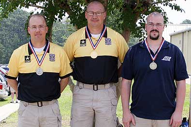 FORT BENNING, Ga.--Sgt. 1st Class Daryl Szarenski, U.S. Army Marksmanship Unit, stands atop the podium after receiving his gold medal for winning the Men's 10m Air Pistol at the National Rifle/Pistol Championships June 17. Szarenski is flanked by his teammate, Sgt. 1st Class Thomas Rose, (left), who came in second and Justin Turner, who came in third. (Photo by Michael Molinaro, USAMU PAO)