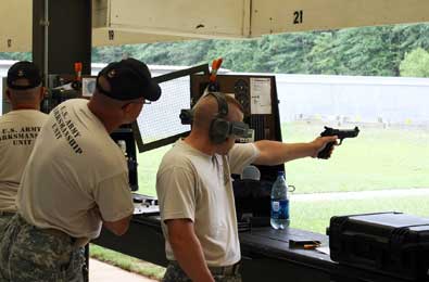 FORT BENNING, Ga.--Staff Sgt. Adam Sokolowski, U.S. Army Marksmanship Unit, concentrates during a team match June 10 at Phillips Range here as team member Staff Sgt. James Henderson looks on in support. The Soldiers were taking part in the 50th Interservice Pistol Championships, where a conglomerate of the top pistol shooters the military has to offer met for some serious yet friendly competition.  (Photo by Michael Molinaro, USAMU PAO)