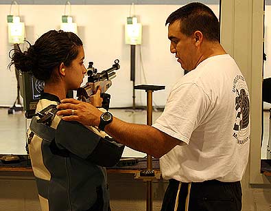 FORT BENNING, Ga.--Staff Sgt. Armando Ayala, U.S. Army Marksmanship Unit, shows the proper positioning Oct. 1 at Pool Indoor Range to a member of the Fort Benning Junior Rifle Club. USAMU NCOs hold clinics, conduct schools, and train more than 3,000 Soldiers on the proper techniques of marksmanship every year. Out of 91 assigned personnel to the USAMU, 74 are NCOs.  (Photo by Michael Molinaro, USAMU PAO)