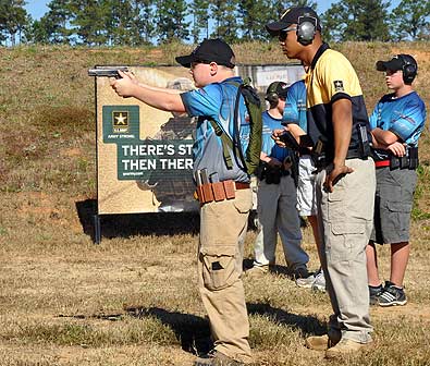 FORT BENNING, Ga. -- 13-year-old James Wall of Parma, Idaho fires on a target under the watchful eye of Sgt. Lee Dimaculangan, U.S. Army Marksmanship Unit. Wall and 47 other children attended the USAMU Action Pistol junior camp Nov. 6-8 at Krilling Range, receiving instruction on reloads, transitioning, draw and accuracy, movement, and an introduction to the rifle. (Photo by Michael Molinaro, USAMU PAO)