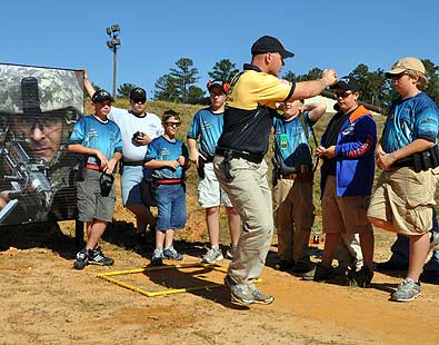 FORT BENNING, Ga. -- Staff Sgt. Travis Tomasie, U.S. Army Marksmanship Unit, displays the correct way of transitioning a shooters body through a course of fire Nov. 7 at Krilling Range. Tomasie and the rest of the USAMU's Action Shooting team held a camp for junior action pistol shooters from all over the country, as kids from California, Idaho, Arizona, and North Carolina, among others, descended on Fort Benning to learn from the best in the world and meet new friends. (Photo by Michael Molinaro, USAMU PAO)