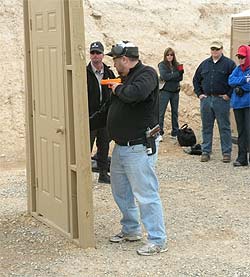 Front Site: Hold the gun in close while you test and open the door.  Our lead instructor, Ben, observing.