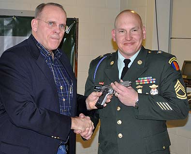 USAMU-Henderson FORT BENNING, Ga. – Col. (RET) Robert I. Hoidahl, Jr, president, Military Marksmanship Association, presents a .45-cal. pistol to Sgt. 1st Class James Henderson, U.S. Army Marksmanship Unit Jan. 29 at Pool Indoor Range. Henderson was named the 2009 MMA Soldier of the Year. (Photo by Michael Molinaro, USAMU PAO)