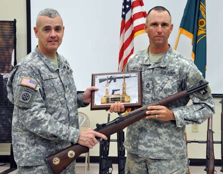 FORT BENNING, Ga.-- Col. Charles Durr, chief of staff, Maneuver Center of Excellence, stands with Sgt. 1st Class Russell Moore, 2nd Battalion, Small Arms Readiness Group, Camp Bullis, Texas, after presenting Moore with a Secretary of the Army M1 Garand Trophy Rifle for winning the 2010 All-Army Small Arms Individual Championship Feb. 27.