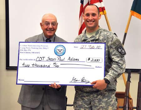 FORT BENNING, Ga.--Mr. J.B. Hudson, civilian marksmanship program, presents a scholarship for $2,000 to Cadet Sean-Paul Adams, North Georgia College and State University, Feb. 27. Five ROTC cadets earned scholarship money after competing in the 2010 All-Army Small Arms Championships. (Photo by Michael Molinaro, USAMU PAO)