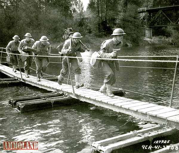 US Army troops armed with a Browning maching gun and 1911 pistols cross a bridge