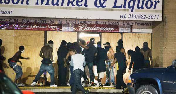 Rioters loot the Ferguson Market and Liquor store on August 16, 2014 in Ferguson, Missouri. Several businesses were looted as police held their position nearby.