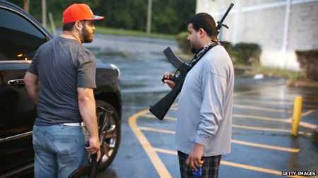 Business owners carry so called "assault weapons" to protect their stores from looters in Ferguson, Missouri