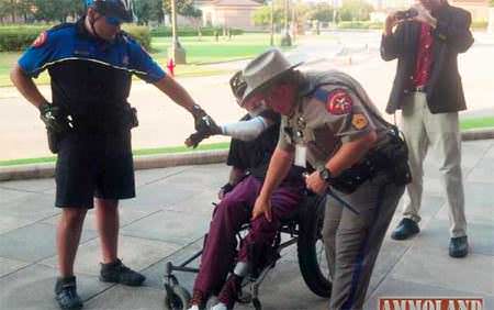 Disabled Open Carry Demonstrator Arrested, The State Trooper, center, has a holstered antique revolver in his left hand.