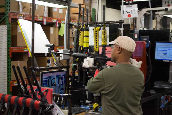 A technician bore sights a new M&P 15 to get the iron sights aligned.