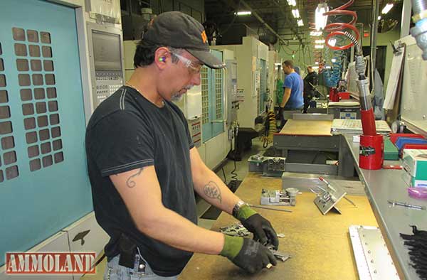 A Henry Arms employee stands next to computer driven milling machines that produce the built in quality of a Henry rifle