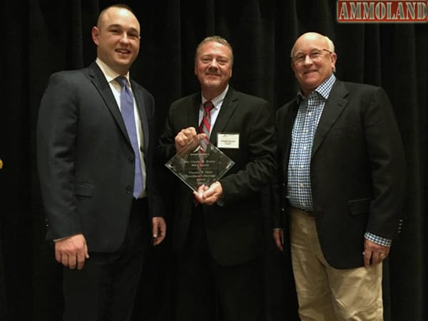 Charles Brown flanked by presenters Evan Huesinkveld (L) of Sportsmen's Alliance and Tommy Millner CEO of Cabelas. 