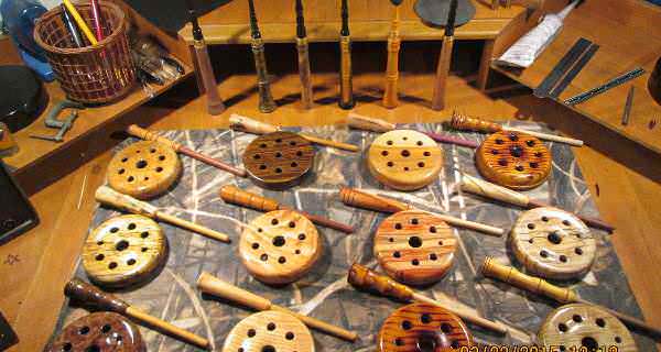 A collection of custom turkey pot calls with turkey trumpet calls in the background.