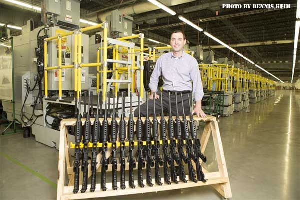 Trip Ferguson, in charge of the new Huntsville manufacturing facility for Remington Outdoor Co., shows off a rack of semi-automatic sporting rifles. Photo By Dennis Keim