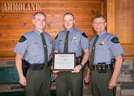 Ogemaw County conservation officer Kyle Bader, center, recently was honored with a DNR Lifesaving Award for his efforts in preventing a man from committing suicide. Bader, flanked by DNR Law Enforcement Division Chief Gary Hagler, left, and Assistant Chief Dean Molnar, right, Bader is shown here receiving the award at the June 9 meeting of the Natural Resources Commission in Gaylord.