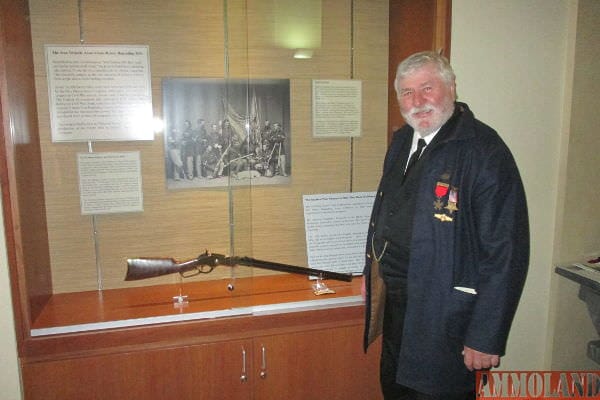 Dr. Lance J. Herdegen standing next to the "Iron Brigade Association Henry Repeating Rifle", on display at the Kenosha Civil War Museum.