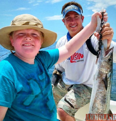 Bobby Dove helps Isaac Hill hold up his first kingfish in the Gulf of Mexico.