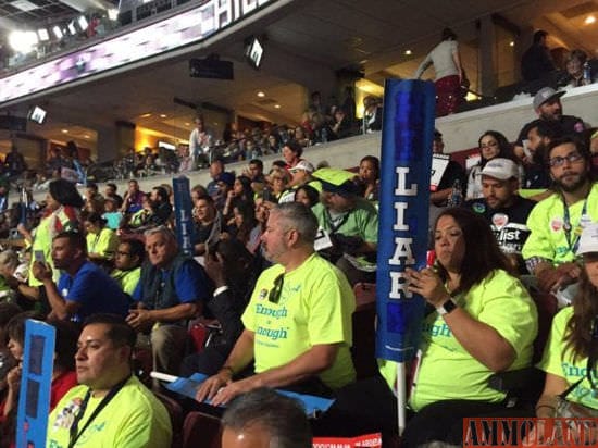 Bernie Sanders supporters paint over letters in their Hillary signs to make them read LIAR.