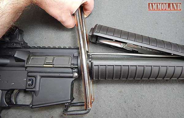 Figure 7: Rearward pressure being applied to the AR handguard removal tool, pulling the delta ring back, and releasing the halves of the rifle handguard. removing an AR 15 A2 front sight