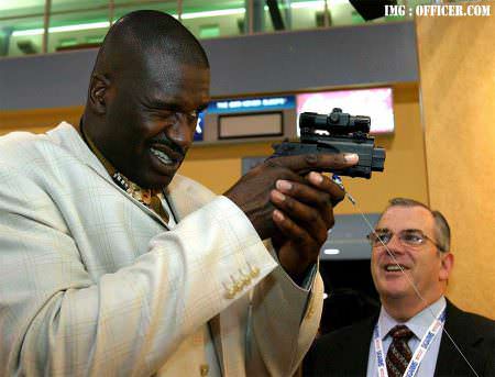 Shaquille O'Neal, left, checks out the SIG SAUER Mosquito handgun.