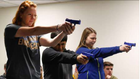 UNK students, from left to right, Keanna Kroeker, Sebastion Gomez and Josie Minor participate in a classroom exercise that tests the reaction time of police when confronted by an armed terrorist. (Photo by Corbey R. Dorsey/UNK Communications)
