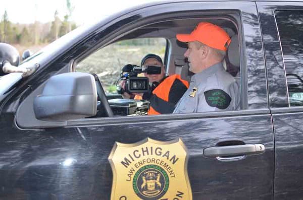Videographer Kristin Ojaniemi and Michigan Department of Natural Resources Conservation Officer Mark Leadman talk in Leadman’s truck, as Ojaniemi films for the “Wardens” television show.