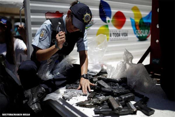 Venezuela Destroys Guns : A police officer hammers a pistol during an exercise to destroy seized weapons in Caracas, Venezuela, August 17, 2016. REUTERS/Marco Bello.