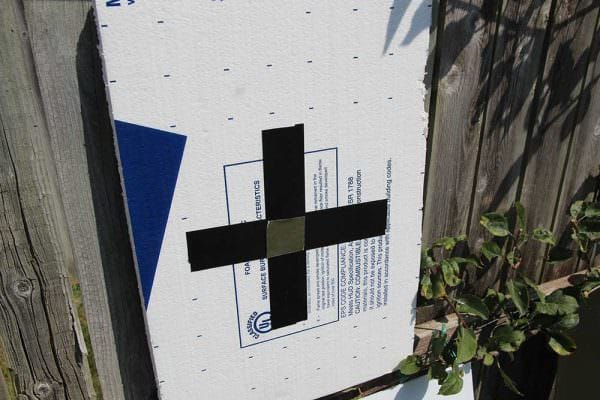 Scrap foam board used as a target. Black 2-inch tape makes a visible target indicator while a small piece of foil tape serves as the aiming point.