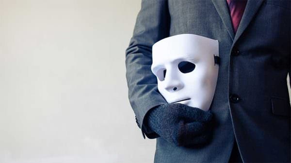 Mask Hidden Agenda Gun Banners Businessman carrying white mask iStock-twinsterphoto 624010374