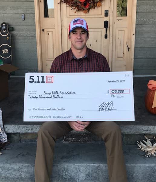 Andy Stumpf holding the $20,000 check from 5.11 to Navy SEAL Foundation