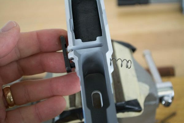 Install the magazine catch lever and spring from the left.