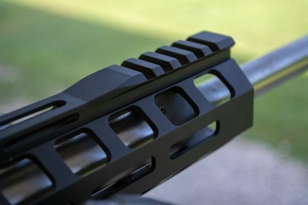 The hand guards use short rail segments front and back with a smooth surface in between. M-LOK is everywhere else.