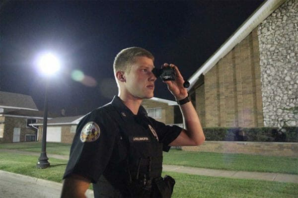 ECPD Patrolman Joe Kelnhofer keeps an eye on a gathering of individuals that disbanded as his partner approached them.