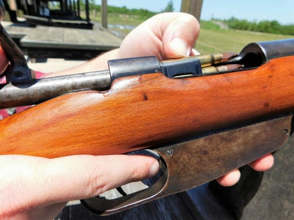 A sheet steel en-bloc clip holding six rounds in one handy packet is pushed into the magazine until a spring-loaded tab locks it in place.