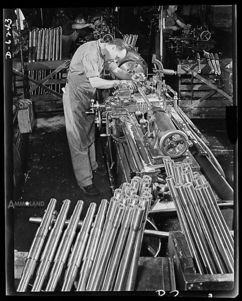 Production Machine Guns: Machine guns of various calibers. Walter Newman, the operator of a high-speed lathe in a large firearms plant, performs an operation on the barrel of a machine gun. Many women workers are also employed in this plant in producing essential weapons for the armed forces