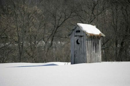 Old Outhouse in Snow Covered Field