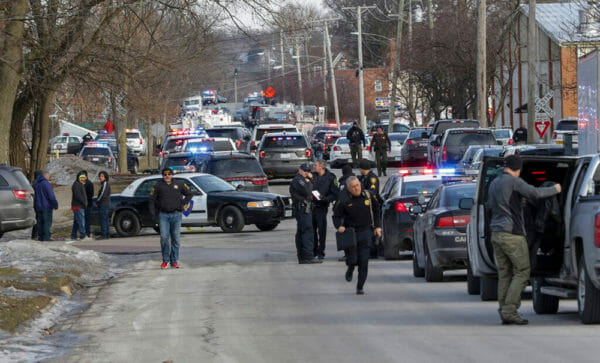 Law enforcement personnel gather near the scene of a shooting at the Henry Pratt company in an industrial park in Aurora, Ill., on Friday. | Bev Horne/Daily Herald via AP