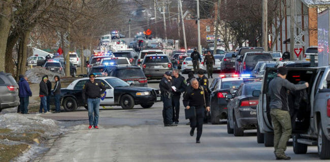 Law enforcement personnel gather near the scene of a shooting at the Henry Pratt company in an industrial park in Aurora, Ill., on Friday. | Bev Horne/Daily Herald via AP