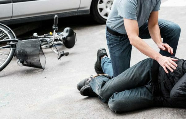 Pedestrian helping Bicycles accident victim iStock-931839776