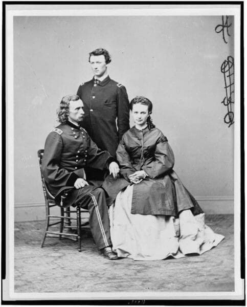 Civil War Union Army Gen. George A. Custer sits beside his wife, Elizabeth Custer. His brother, Lt. Thomas W. Custer, stands behind them, circa 1865.