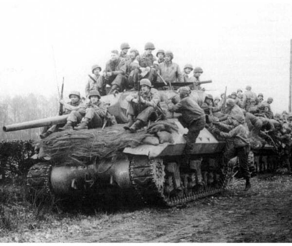 Soldiers with the 823rd Tank Destroyer Battalion and 30th Infantry Division sit on tanks near Mortain, France, Dec. 25, 1944. The units held off Germany’s elite 1st and 2nd Panzer Divisions, ensuring the success of the Normandy breakout and victories at Saint-Lô.