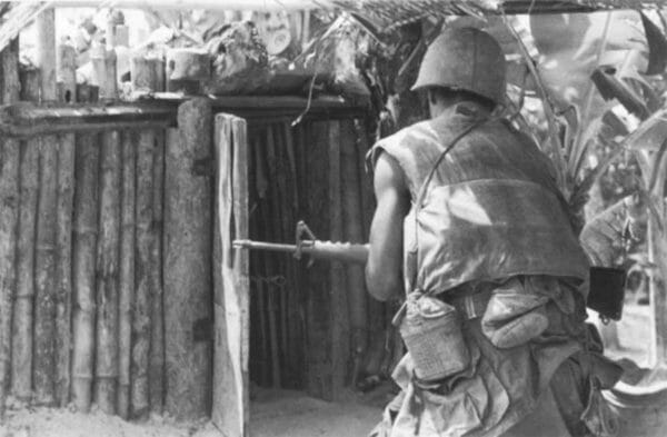 A Marine from 2nd Battalion, 7th Marines, cautiously approaches a damaged hut during Operation Allen Brook. The Viet Cong dominated the small villages on Go Noi Island in Vietnam.