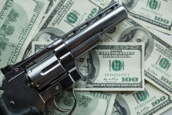 Revolver gun money iStock-1060256694