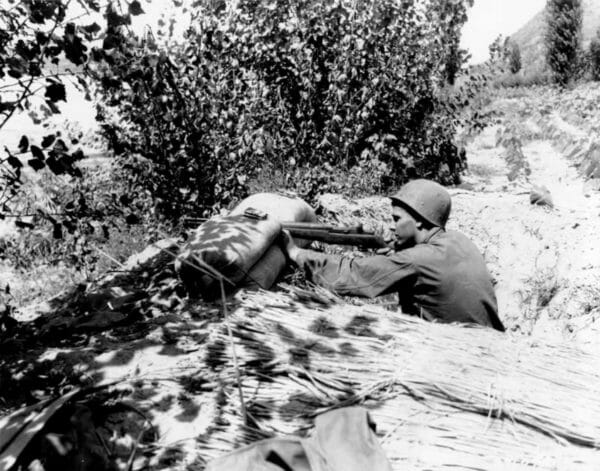 Army Pfc. Letcher V. Gardner of the 8th Cavalry, 1st Cavalry Division, fires on an emplacement of the Communist-led North Koreans along the Naktong River near Chingu, Aug. 3, 1950.