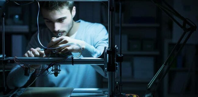 Young engineer working on a 3D printer 3d guns ghost iStock-demaerre 586694292