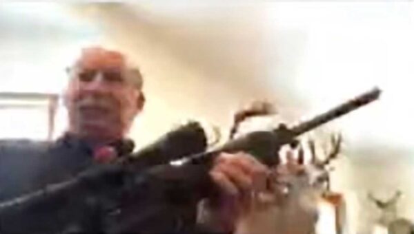 Grand Traverse County Commissioner Ron Clous briefly displayed a rifle on camera