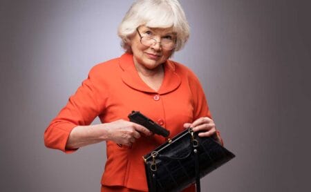 Old Elderly woman putting gun in handbag iStock-ALotOfPeople 686588266